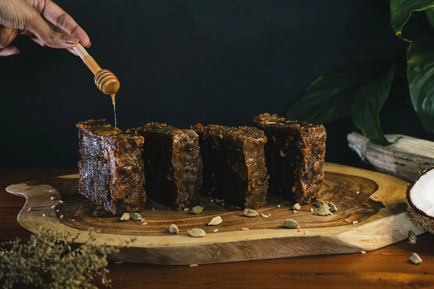 Honey being drizzled over slabs of dodol