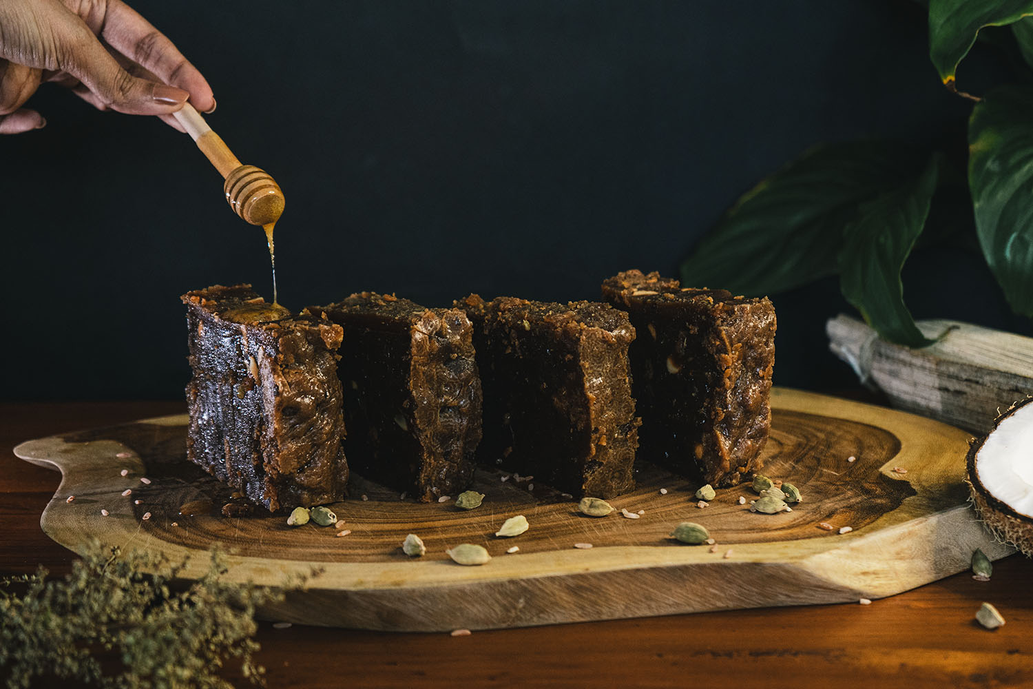 Honey being drizzled over slabs of dodol